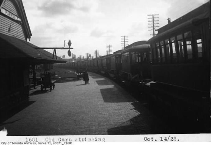 photograph of old Toronto Railway Company streetcar being sent on Canadian National Railway flatcars at Parkdale Station. One of many old car bodies slupped north to Haileybury, Ontario to serve as temporary housing due to recent forest fire that devastated the town taken October 14, 1922.