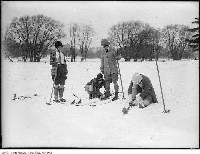 Ski-ing, four girls putting on skis. - January 17, 1926 - vintage skiing photographs