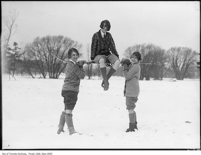 Ski-ing, two girls holding one on skis on shoulders. - January 17, 1926 - vintage skiing photographs