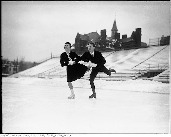 Stewart Reburn and Sonie Henie, skating team, skating on rink in Varsity Stadium