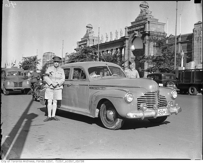 Armed forces men and automobile in OC Cavalcade, by Princes' Gates 1941