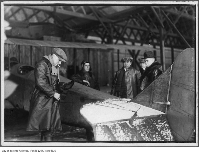 Aviator Bert Acosta prepares to take William James Sr. up in airplane, Leaside. - 1916 - photograph taken just before William James Sr. took the first movies from the air in Canada. Other subjects include F.G. Ericson (in checkered cap) and head of construction Sir Frank Baillie (right) - Vintage Airplane Photographs