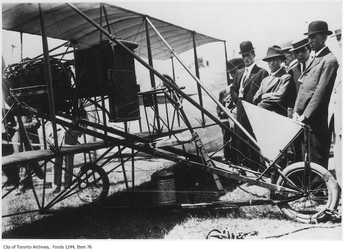 Lincoln Beachey's airplane. - 1910 - photograph of men examining an airplane. Information provided by a researcher indicates that the airplane is probably Lincoln Beachey's Curtiss-type Pusher bi-plane with 8-cylinder Curtiss V-8 engine and no forward control surfaces, and that the event is probably the Buffalo Aero Club Aviation Meet, Fort Erie, Ontario, June 20-24, 1911. The man with his arms folded is Frank H. Ellis, author of Canada's Flying Heritage.