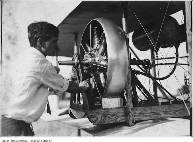 Man working on McCurdy's plane. - 1910 - photograph of a man working on an airplane engine. Information provided by a researcher indicates that it is probably J.A.D. McCurdy's bi-plane with 7-cylinder Gnome rotary engine, and that the event is probably either the Aviation Meet held at Donlands Farm, Todmorden Mills, August 3-5, 1911, or the Aviation Meet, Hamilton, July 27-29, 1911.