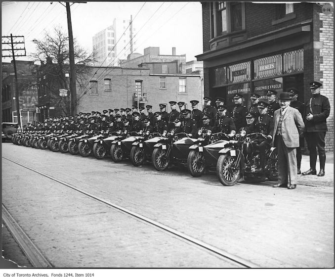 Police motorcyle division. - [between 1926 and 1930] Chief Draper is at right. A researcher has identified the location as 69 Dundas Street West, east of Police Station 2, which was at #75-85, between Yonge and Bay streets.