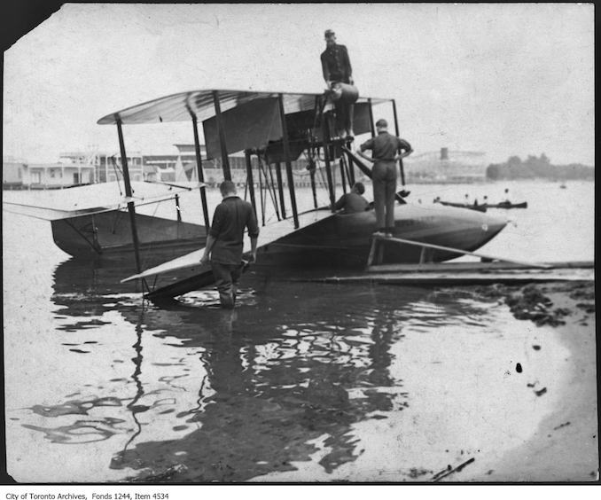 Putting gasoline in T.C. MacCauley's Curtiss F flyboat. - 1915 - photograph. The airplane may have been called the Maple Leaf.