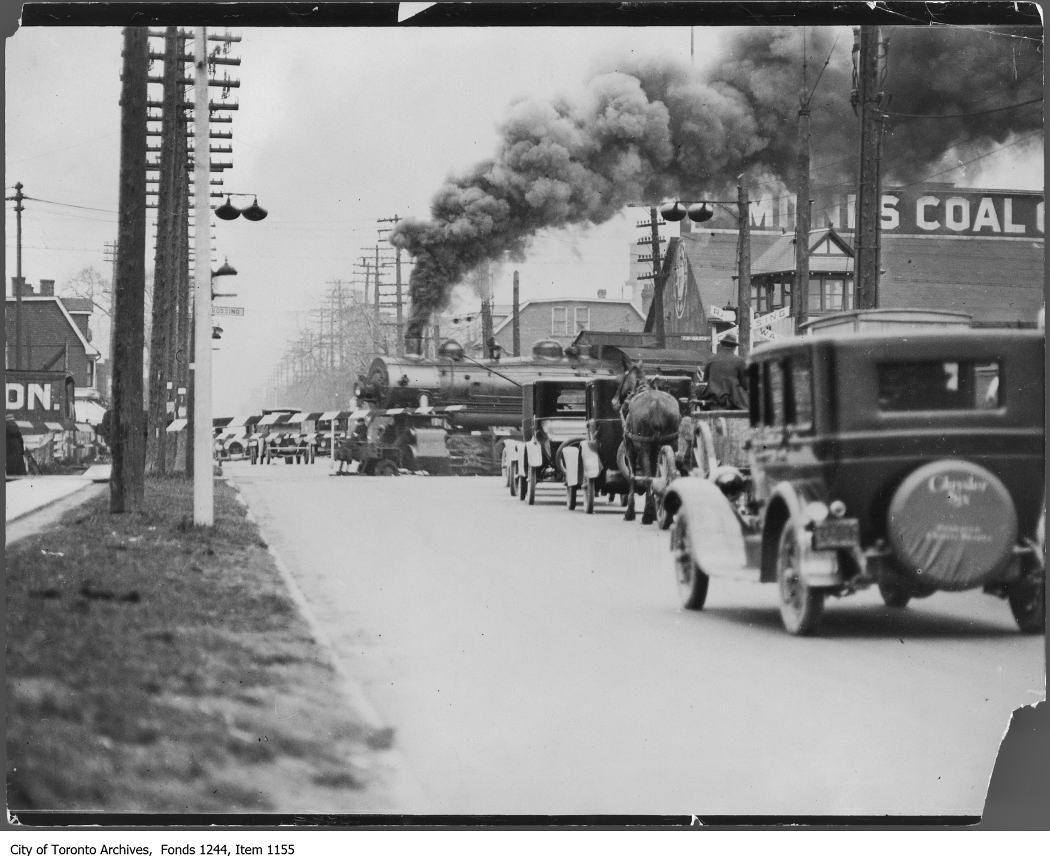 Traffic stopped for passing train at level crossing - 1929