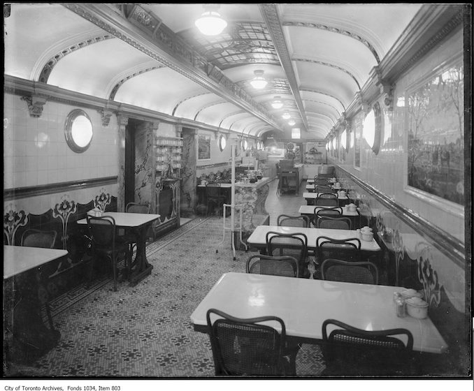 ca. 1916 - Interior of long narrow restaurant with bentwood chairs, mosaic floor and ceiling reminiscent of a railway car