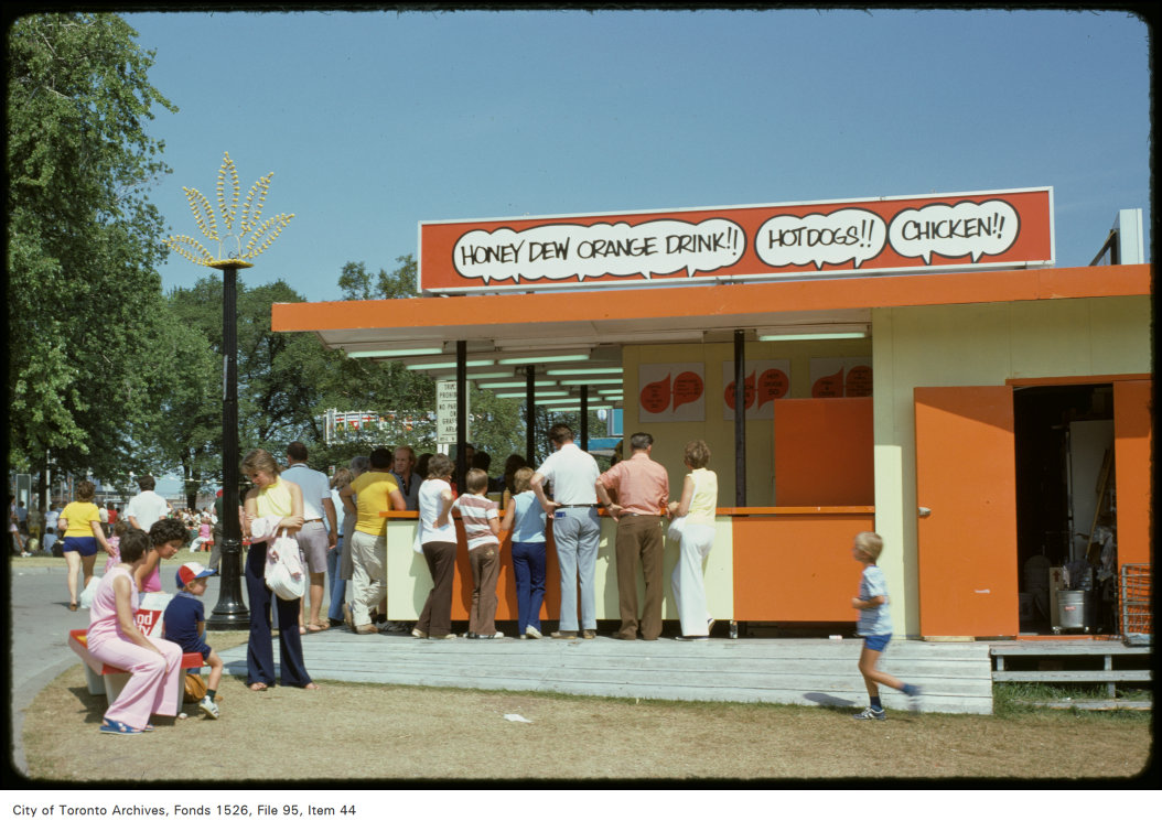 1974 - View of people standing at food stand on CNE grounds