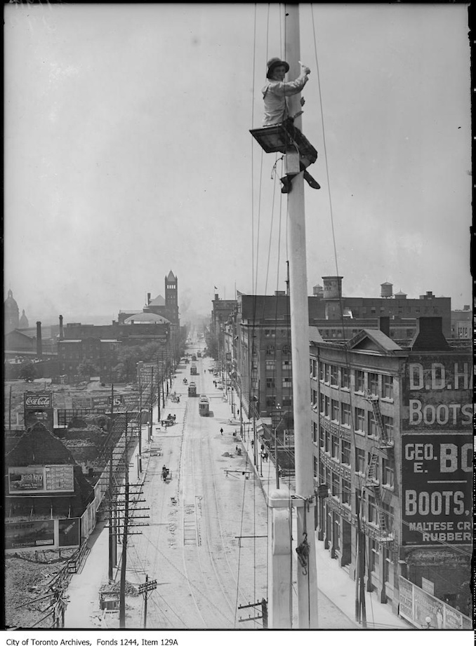 1907 - Flagpole painter with view looking west on Front Street from Yonge Street