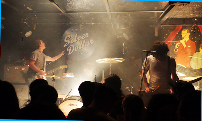 Metz take down the stage sign as a smart man playing a clarinet looks on