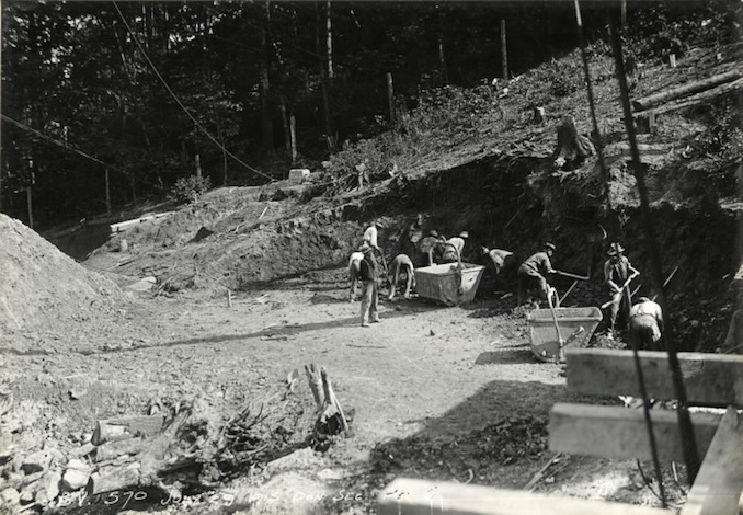 1915 - Construction workers digging out bank for pier G