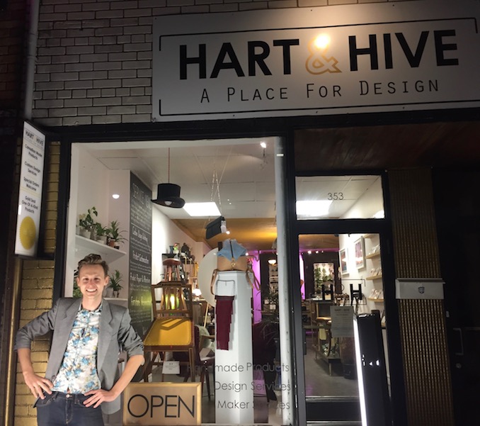 Thomas stands in front of his design studio and store, Hart & Hive. The facade of his shop is eye catching with all the brickwork painted in metallic gold. 