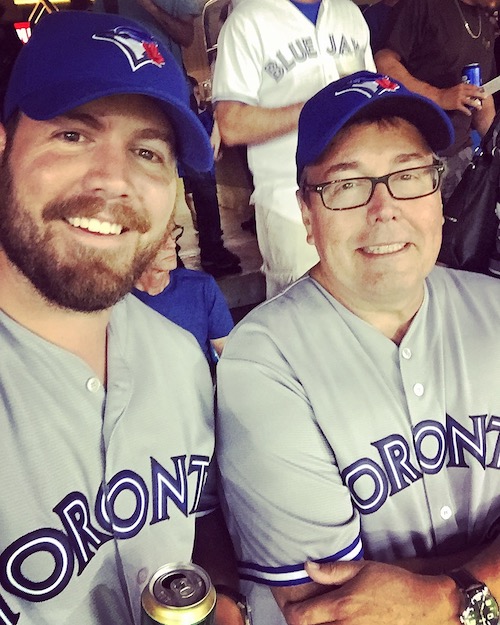 Father and son taking in a Jays game during the summer