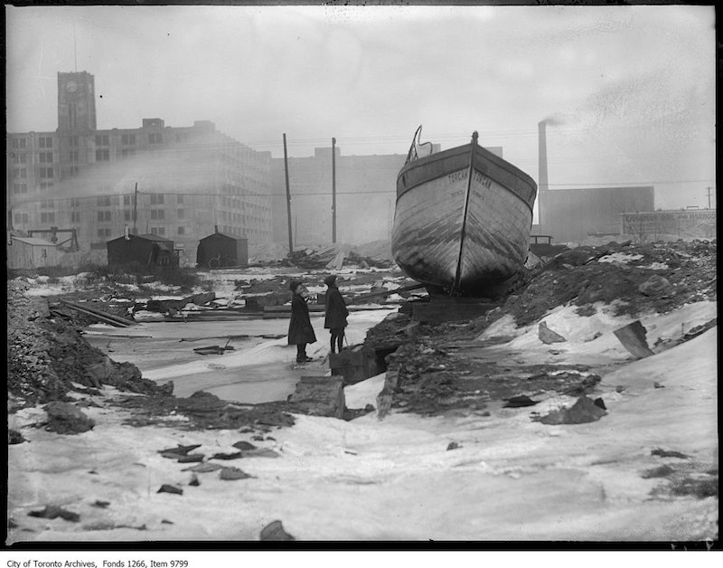 1927 - Waterfront, abandoned boat, warehouse in background