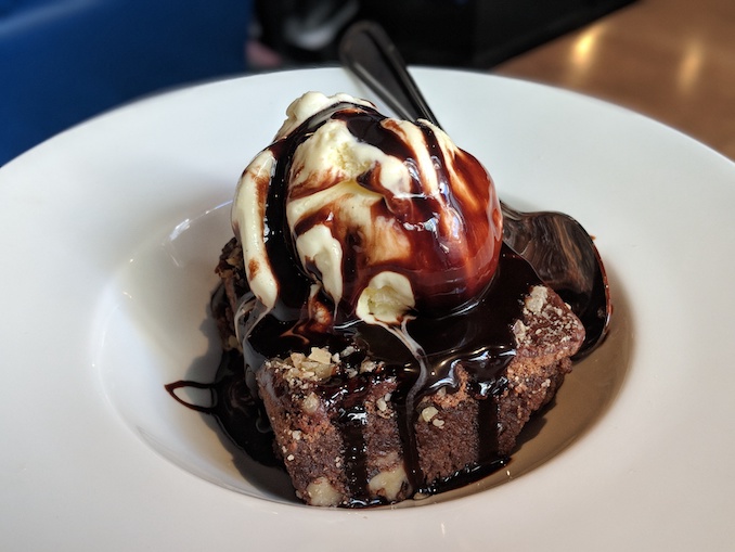 Warm Walnut Brownie A-La Mode: topped with chocolate syrup and vanilla ice cream