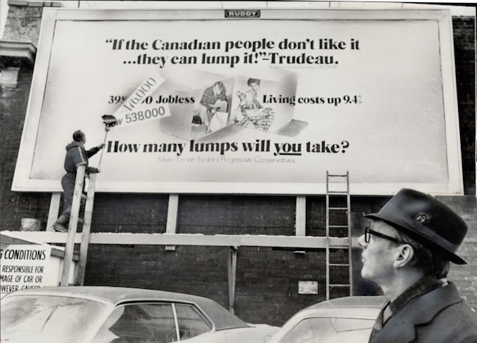 1971 - Rising unemployment figures are posted on a Toronto billboard by workman Chris Hansen while Opposition leader Robert Stanfield - on nationwide tour to publicize unemployment problem