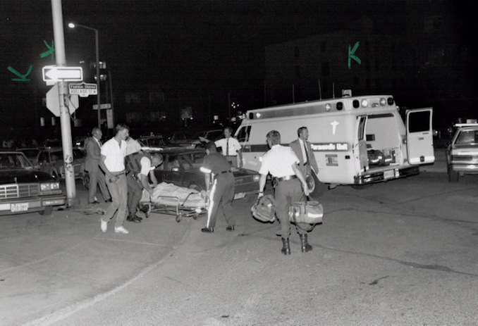 1991 - Don Dutton - Police officers and attendants take wounded officer to waiting ambulance that took him to Toronto Western Hospital last night.
