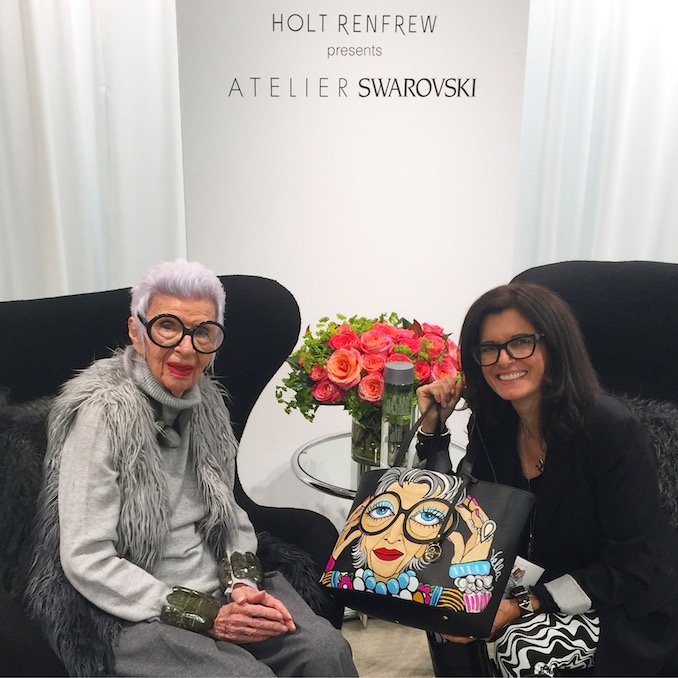 Michelle with Iris Apfel holding a hand-painted Bidinis Italian Leather Bag outfitted with Iris’s portrait.