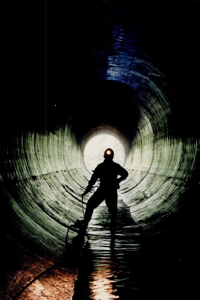 1987 - Bonie Bertumen stands in a 12-foot sewer; one of the many running below Metro. The smelll stops bothering you; he says; after working there 20 or 30 years - Mike Slaughter