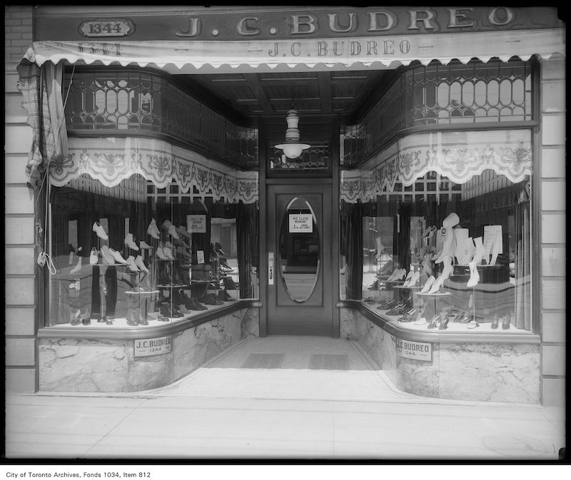 1913 - Window display of ladies and gentlemen's shoes, with leaded upper windows and Humphrey arc gas light, J. C. Buidreo, 1344 Queen Street West