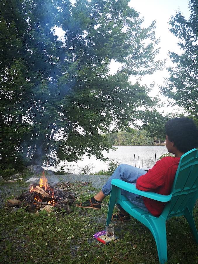 Andrea enjoying a fire by the lake in beautiful Nova Scotia, a place she visits every summer.