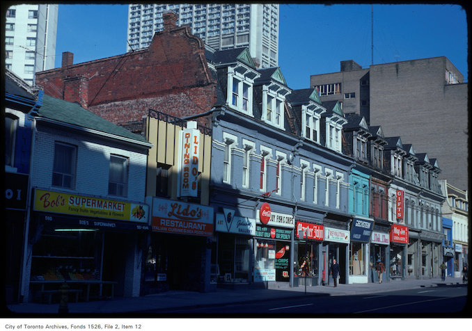 1975 - April 22 - View of stores along the west side of Yonge Street, south of Bloor Street West