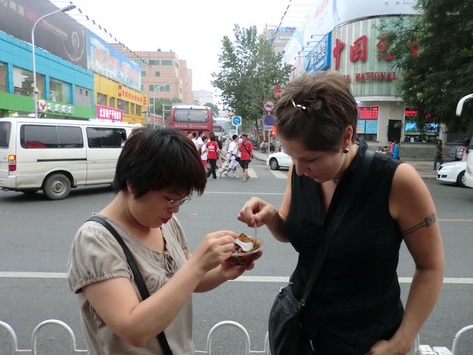 Jane Tingley - in Beijing, China for the exhibition of Plant(iPod)Installation in the Triennial for New Media Art 2011 – Tasting street food with my installation assistant