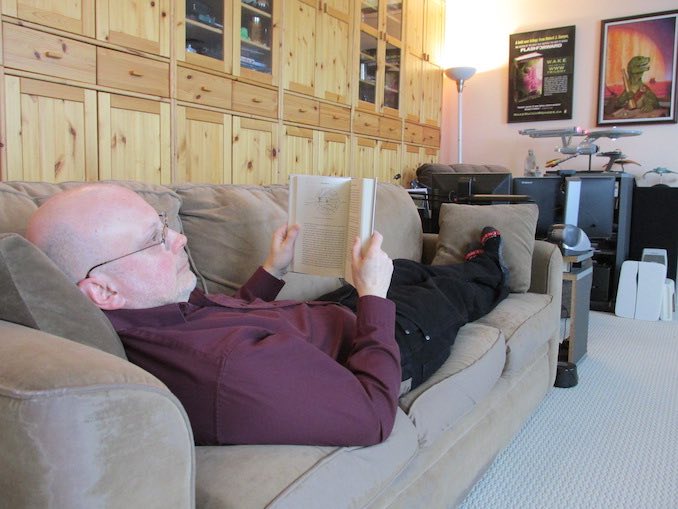 For a writer, the greatest pleasure is reading — and this is my favourite spot (with a few of my “toys” visible in the background).