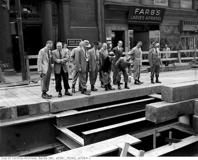 1950 - July 12 - Group of men standing on decking of Yonge Subway during construction