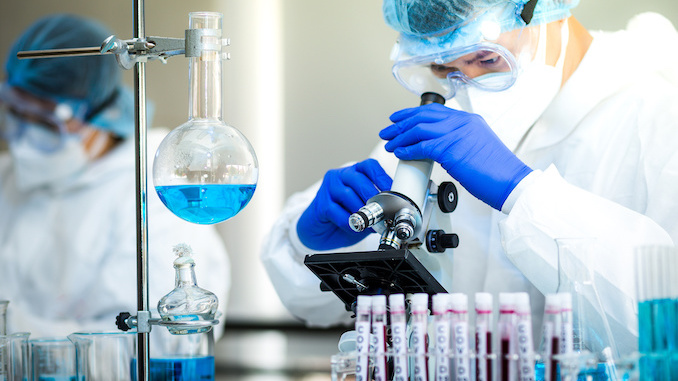 Scientist or researcher hand in blue gloves holding flu, measles, coronavirus, covid-19 vaccine disease preparing for human clinical trials vaccination shot, medicine and drug concept.