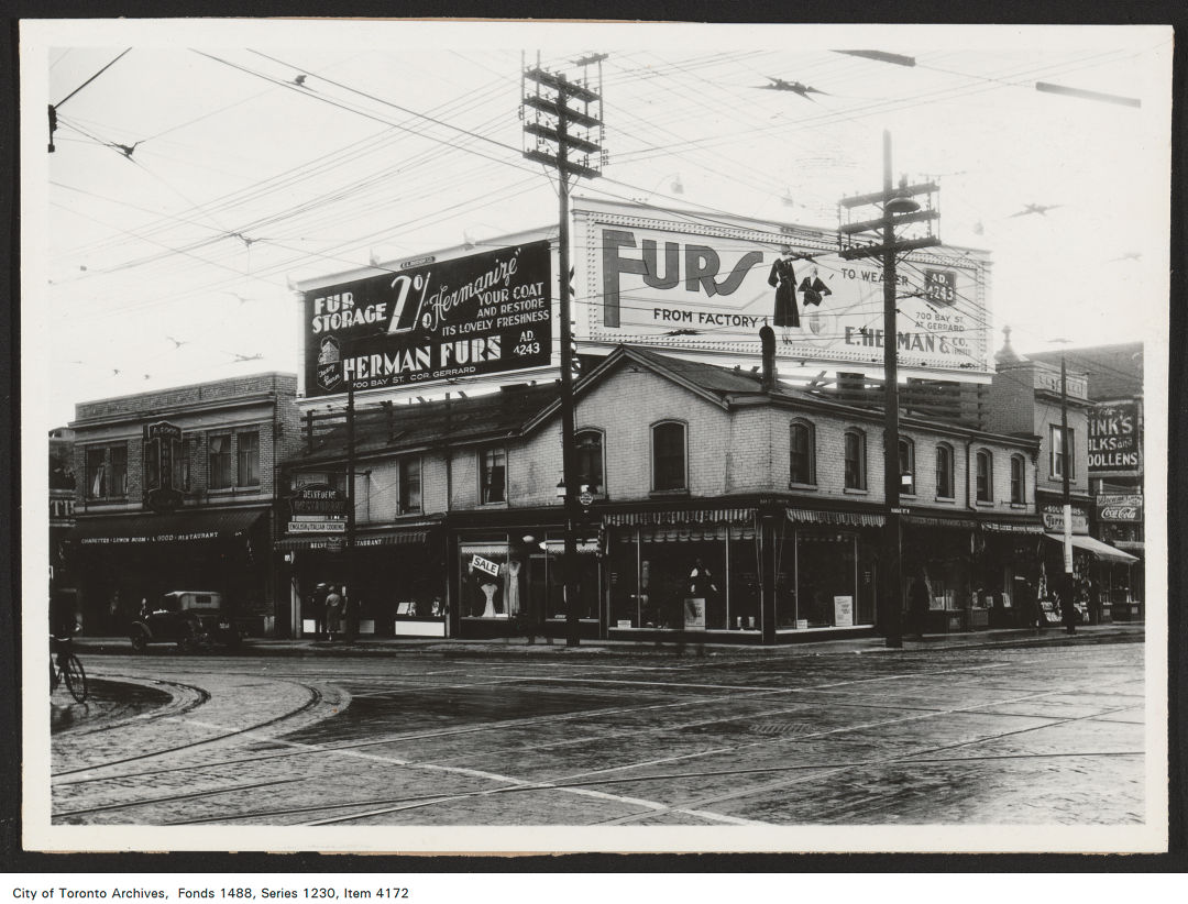 1930 - 1935 - photograph of two rooftop billboards atop a building located at the south-west corner of Bay Street and Dundas Street West.