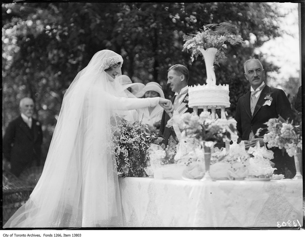 1928 - Kirkpatrick-Burnham wedding, bride cutting cake, groom and Col. Kirkpatrick in background