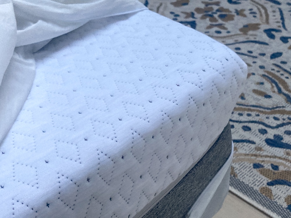 Photograph of a Queen sized Endy Mattress in a cabin with a floor rug in the background