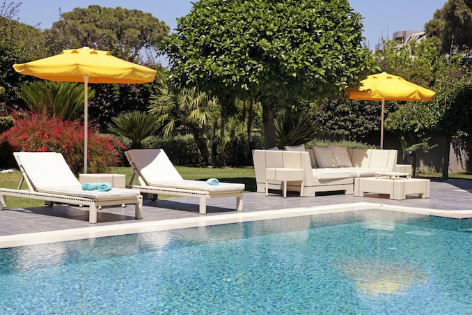 white outdoor furniture in the garden near the swimming pool for relax on beautiful summer resort