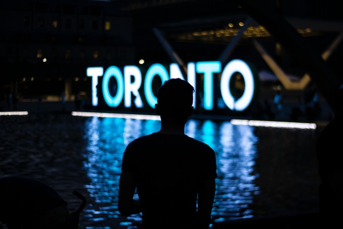 Silhouette in front of Toronto sign.