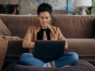 Woman using a laptop on her living room floor. featured image