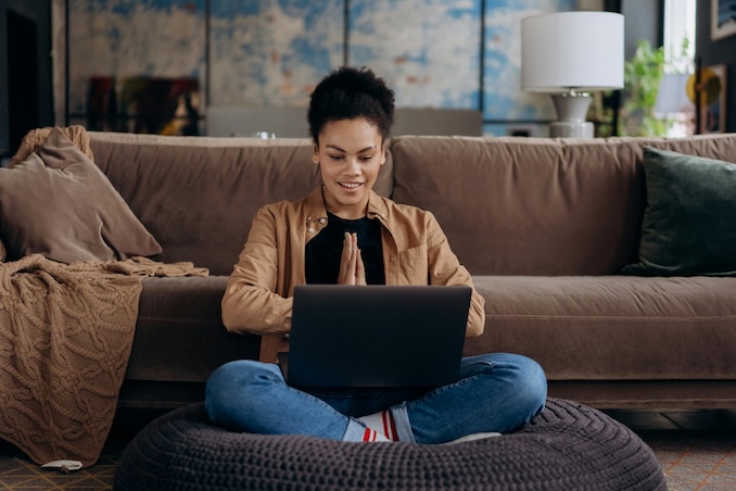 Woman using a laptop on her living room floor.