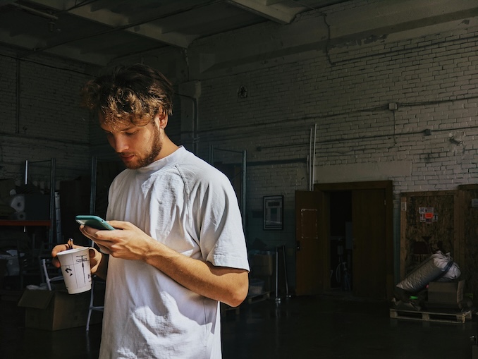 Guy using a cell phone in his garage