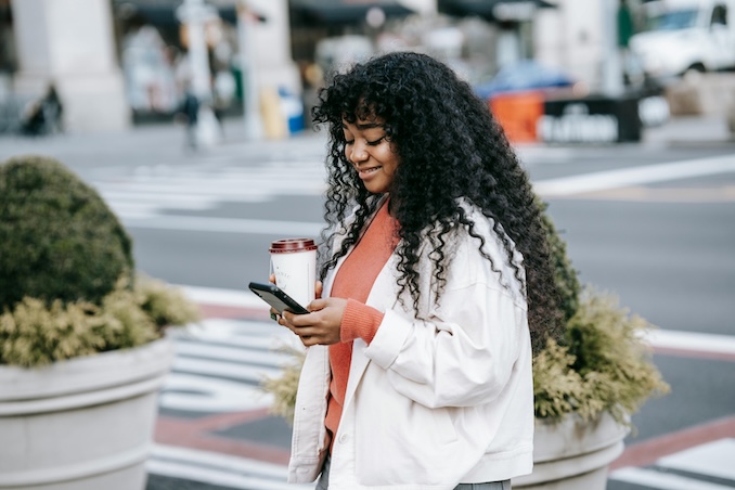 Woman using her cell phone on a downtown street.
