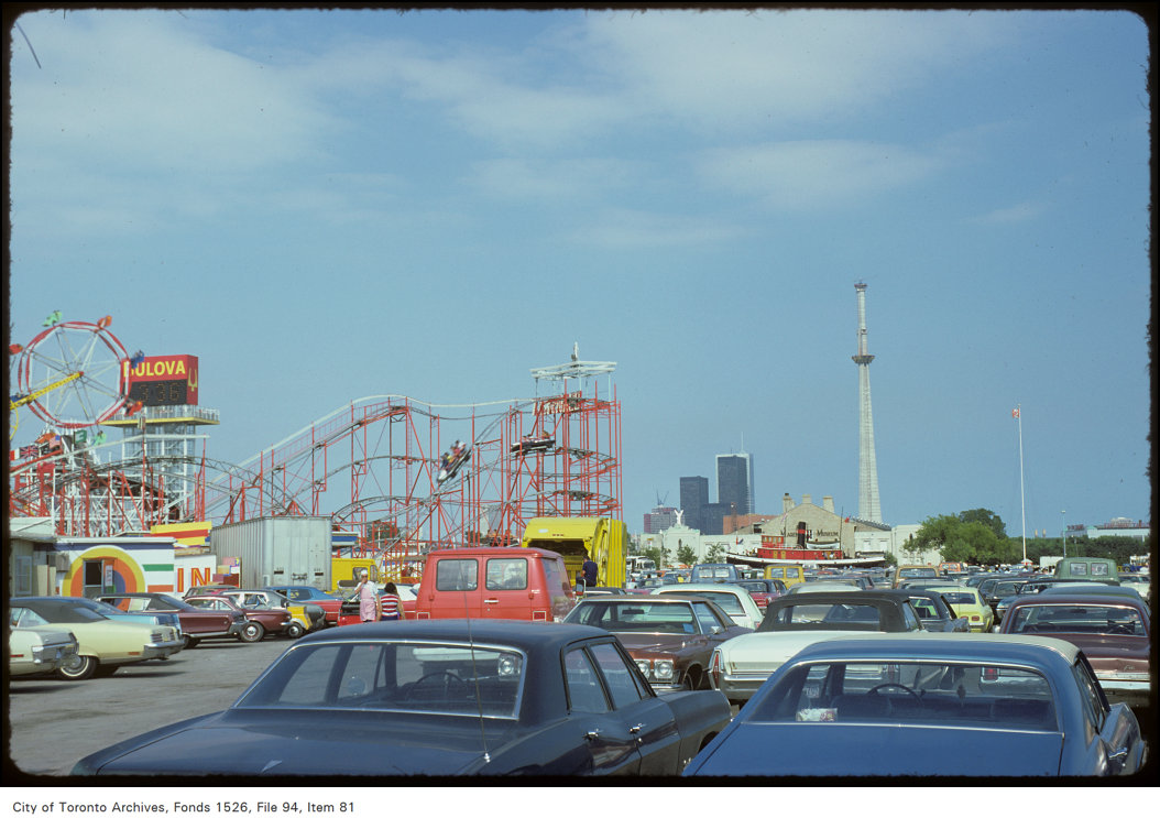 CN Tower under construction with CNE and cars in foreground