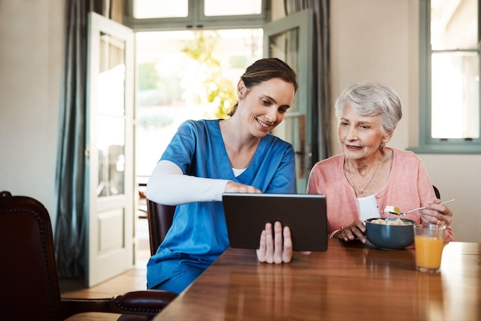 nurse helping elderly at home patient